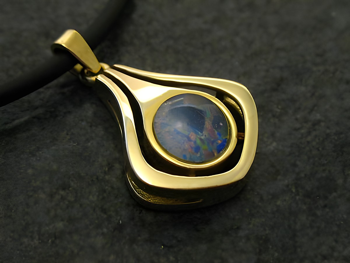 Goldanhänger mit einem Opal Triplette von 20 mm, elegant gestaltet mit geschwungenen Linien, auf schwarzem Hintergrund. Hersteller Juwelier Harnisch.