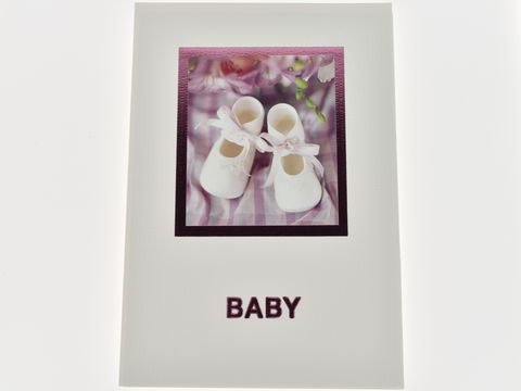 Glückwunschkarte mit Babyschuhen in Weiß und rosa Schleife, umgeben von Blumen, auf einem karierten Hintergrund, Hersteller Juwelier Harnisch.