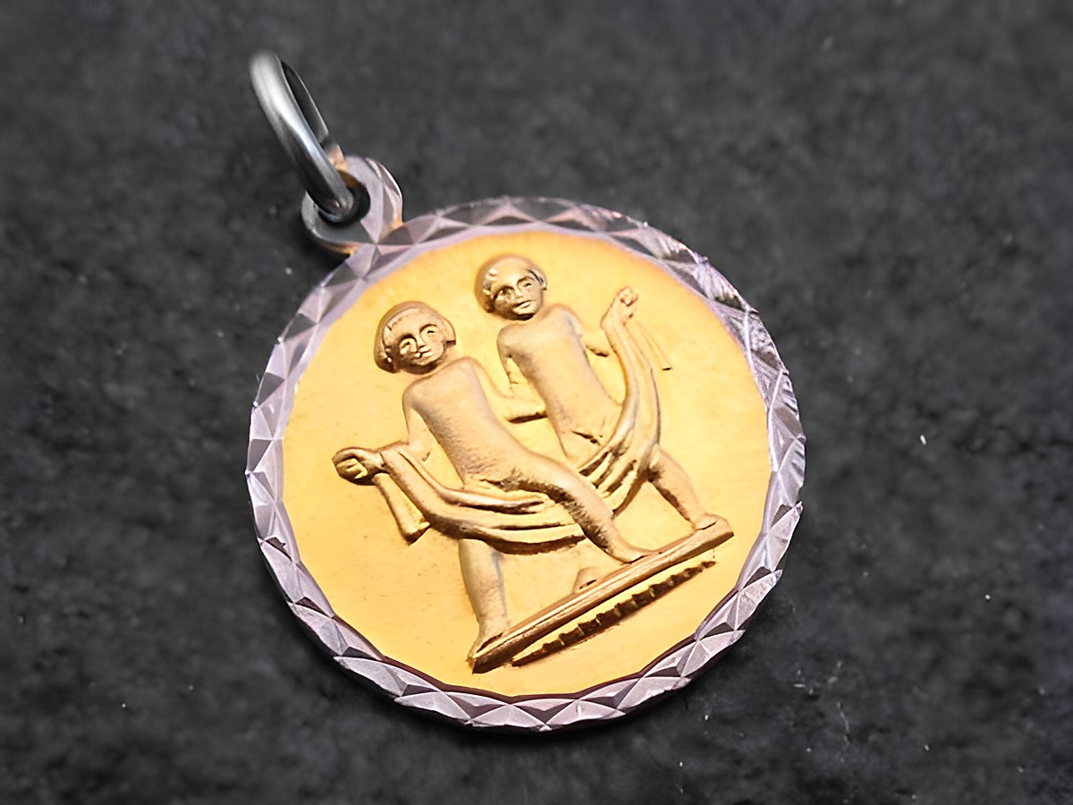 Anhänger mit dem Sternzeichen Zwillinge, aus Gold und Silber, hergestellt von Juwelier Harnisch. Zeigt zwei stilisierte Figuren, die harmonisch miteinander verbunden sind.