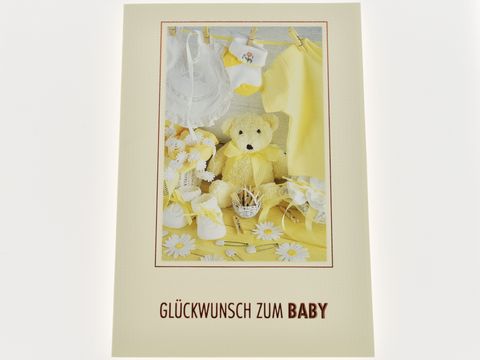 Glückwunschkarte zur Geburt eines Babys mit verschiedenen Baby-Sachen in Gelb und Weiß, darunter ein Teddybär, Babykleidung und Accessoires, Hersteller Juwelier Harnisch.