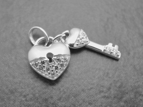 Ein zauberhafter Anhänger aus Sterling Silber in Herzform mit einem Schlüssel, besetzt mit funkelndem Zirkonia, von Juwelier Harnisch.