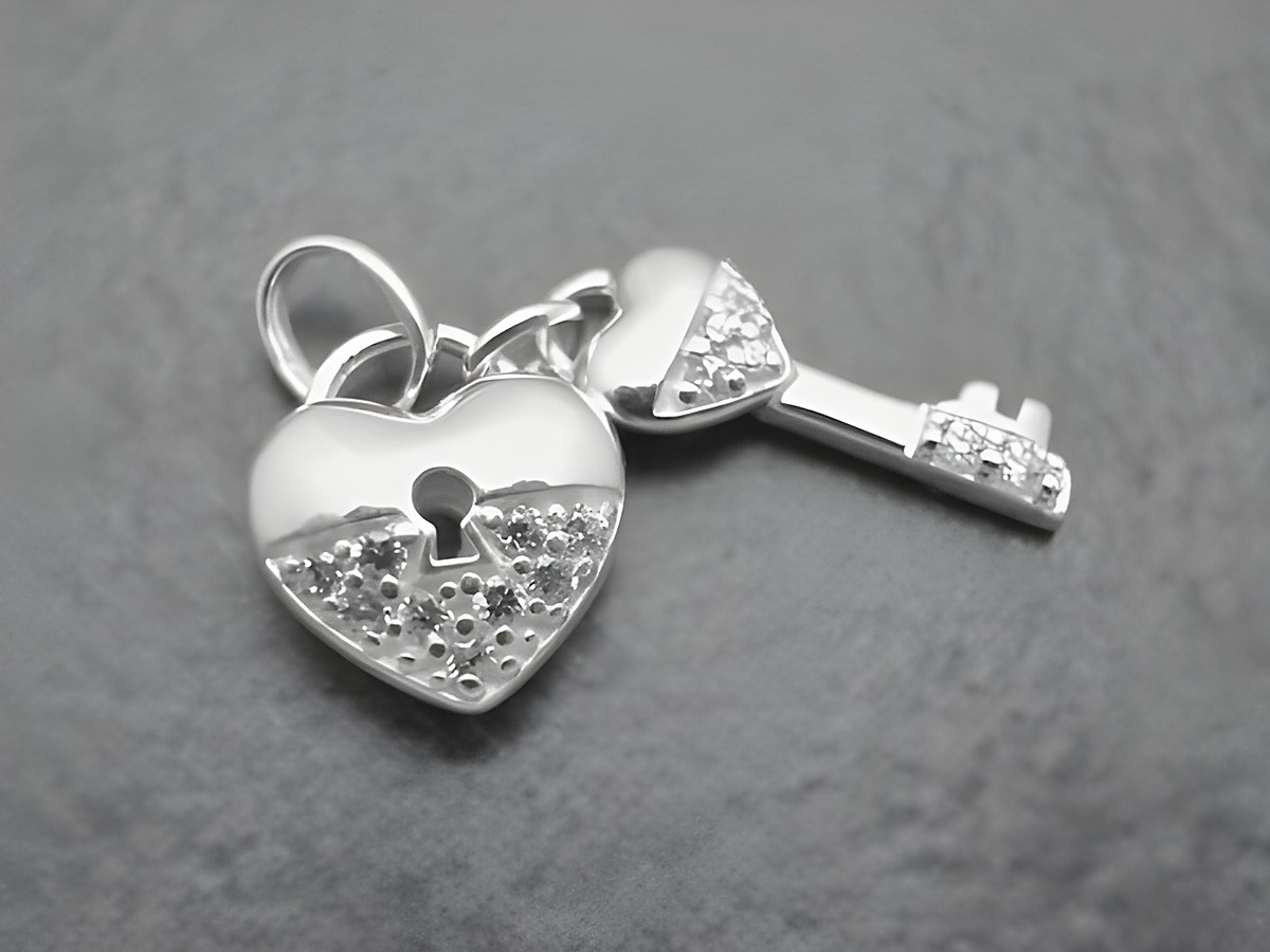 Ein zauberhafter Anhänger aus Sterling Silber in Herzform mit einem Schlüssel, besetzt mit funkelndem Zirkonia, von Juwelier Harnisch.