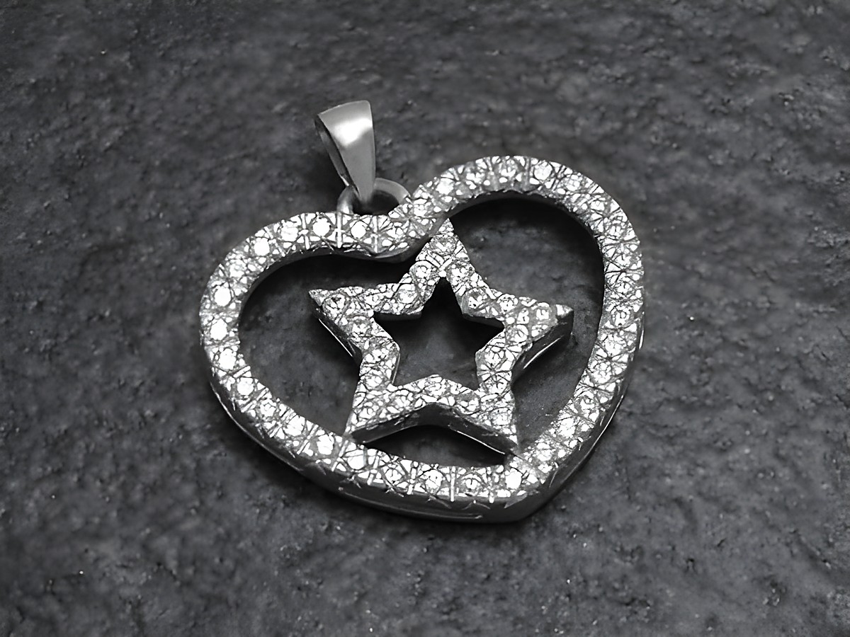 Ein Anhänger in Form eines Herzens mit einem innenliegenden Stern, hergestellt aus rhodiniertem Sterling Silber und besetzt mit Zirkonia, von Juwelier Harnisch, inspiriert von Sonne, Mond und Sternen.