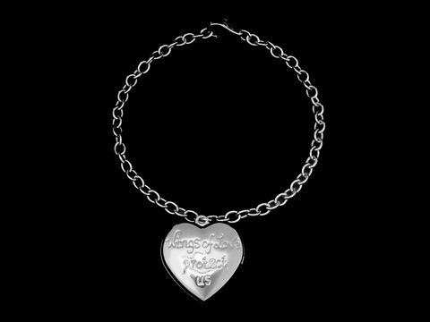 Silber Armband mit Medaillon in Herzform und Flügelmotiven, graviert mit der Aufschrift Wings of Love protect us, hergestellt von Juwelier Harnisch, ohne Stein.